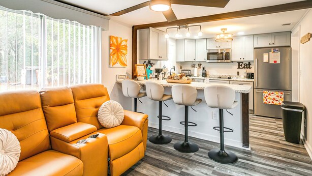 A modern kitchen with a central island, bar stools, and a ceiling fan. - Near Hospital and Restaurants: Quiet & Relaxing (Waycross)
