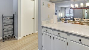 A kitchen with white cabinets, a marble countertop, and a black wire shelf. - 5 Mi to Loon Mountain Resort! Family Townhome (North Woodstock)