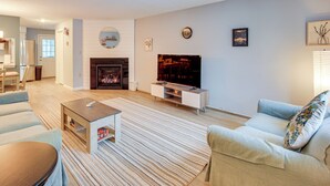 A living room with a fireplace, a television, and a sofa. - 5 Mi to Loon Mountain Resort! Family Townhome (North Woodstock)