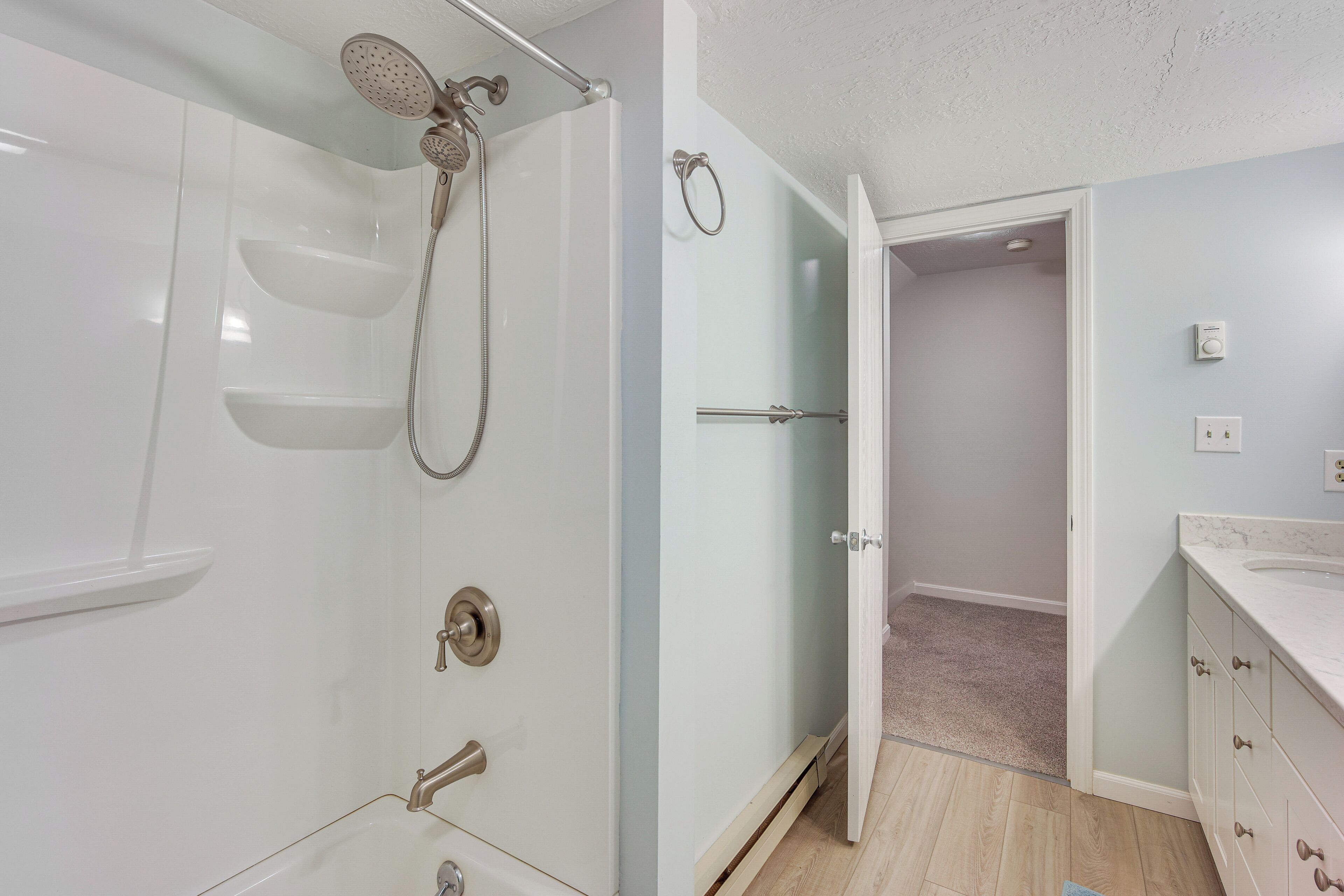 Une salle de bain moderne avec une douche à parois de verre, un lavabo et un meuble-lavabo avec un miroir.