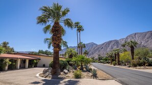A residential street with palm trees, a house with a red roof, and mountains in the background. - Poolside Splendor! Spacious De Anza Golf Club Home (Borrego Springs)