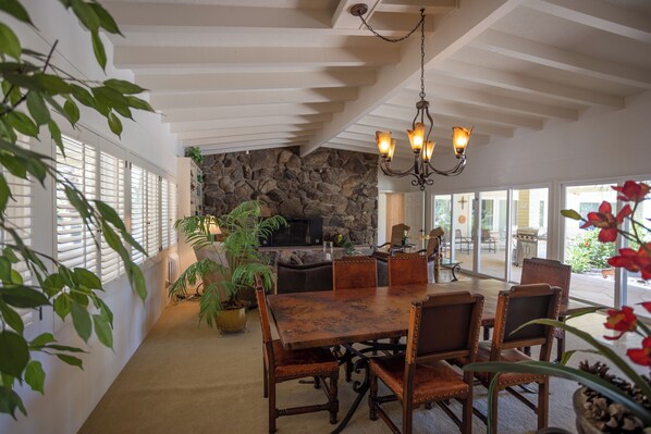 A dining area with a stone wall, wooden table, and chairs.