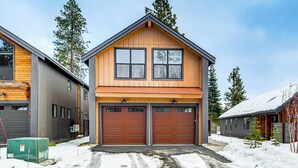 Et toetagers hus med garage, træfacade og sneklædt indkørsel.