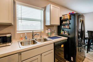 A kitchen with a stainless steel sink, a microwave, a dishwasher, and a refrigerator with a built-in ice maker. - 2 Mi to Historic Dtwn Magnolia: Family Retreat (Magnolia)
