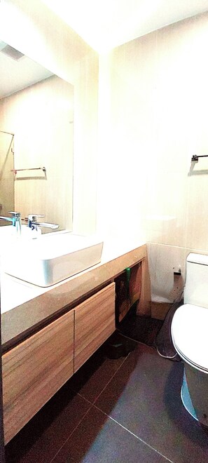 A bathroom with a sink, mirror, and toilet. - Peaceful SEA View Condo (Pattaya)