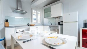 Een moderne keuken met witte kasten, een centraal eiland en een roestvrijstalen afzuigkap.