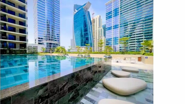 Ein modernes Hotel mit Pool, Hochhäusern und Außenbereich.