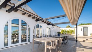 Un pati exterior amb taula i cadires, una pérgola i vista al carrer.