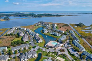 A residential area with houses, a swimming pool, and a large body of water. - 3 bed,3.5 bath Townhome in Bayville Shores! Close to Fenwick Island & Ocean City Beaches, Community Pool, Hot Tub, Fitness Center, Tennis, Free WIFI! (Selbyville)