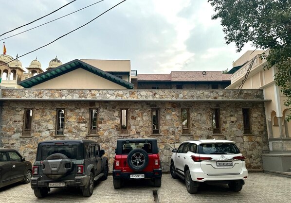 A stone building with three parked cars in front.