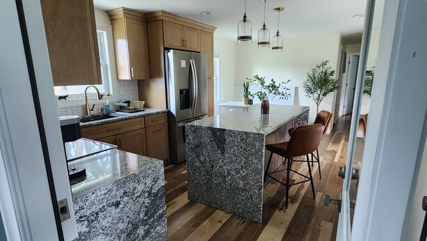 A modern kitchen with granite countertops, wooden cabinets, and a stainless steel refrigerator. - Adorable 3-bedroom 2-bath House in quiet, safe, kid/pet friendly neighborhood. (Enfield)