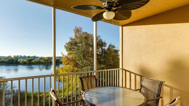 A balcony with a table and chairs, overlooking a lake. - Welcome to Carefree in Calysle in Bonital Springs1 (Bonita Springs)