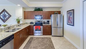 A modern kitchen with granite countertops, stainless steel appliances, and wooden cabinets. - Welcome to Carefree in Calysle in Bonital Springs1 (Bonita Springs)