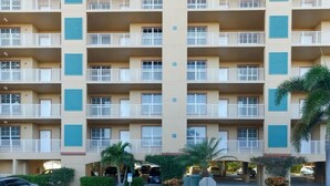 A multi-story hotel with balconies, parking, and a central courtyard. - Welcome to Carefree in Calysle in Bonital Springs1 (Bonita Springs)