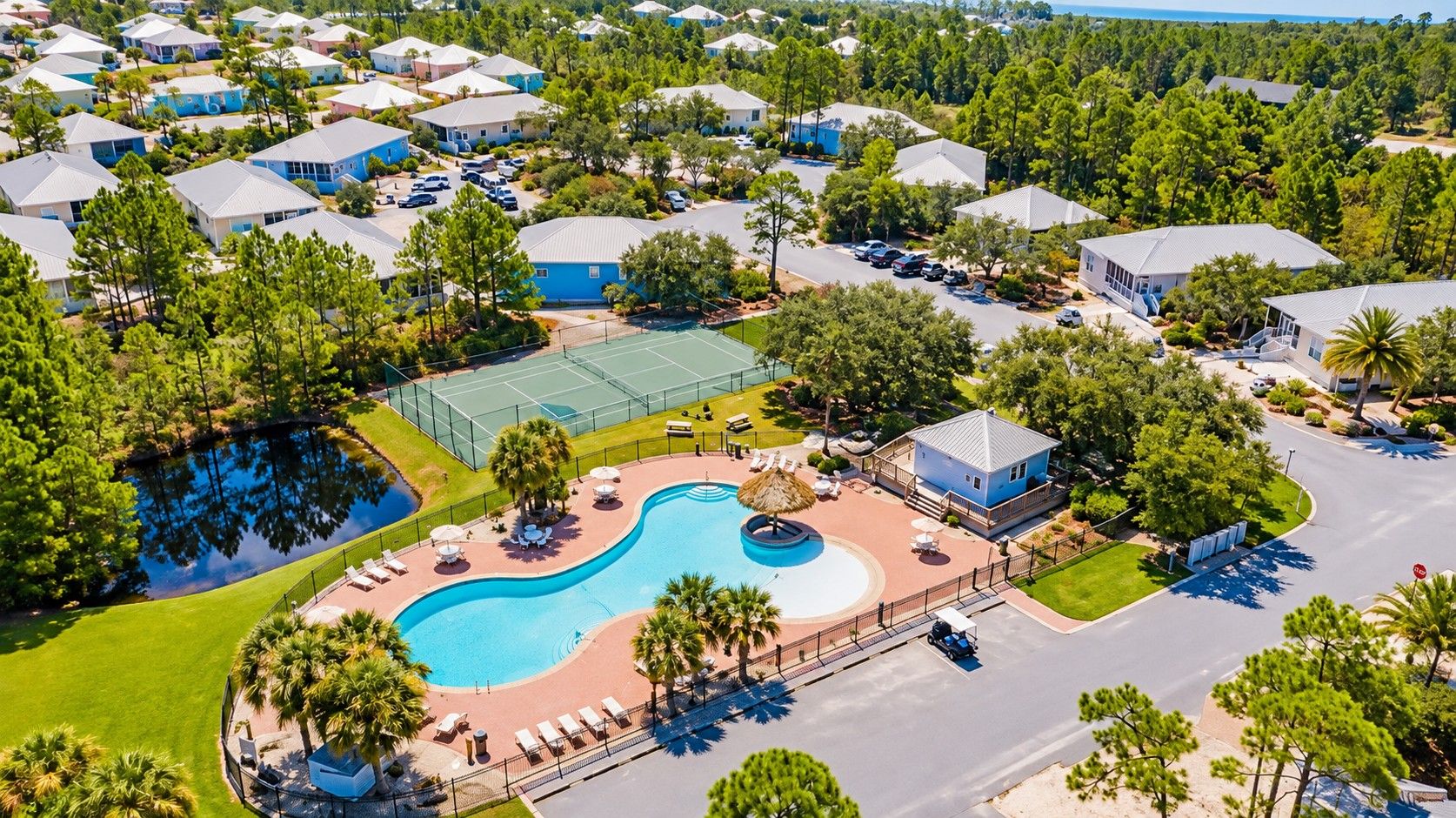 A residential area with multiple houses, a swimming pool, and a tennis court.