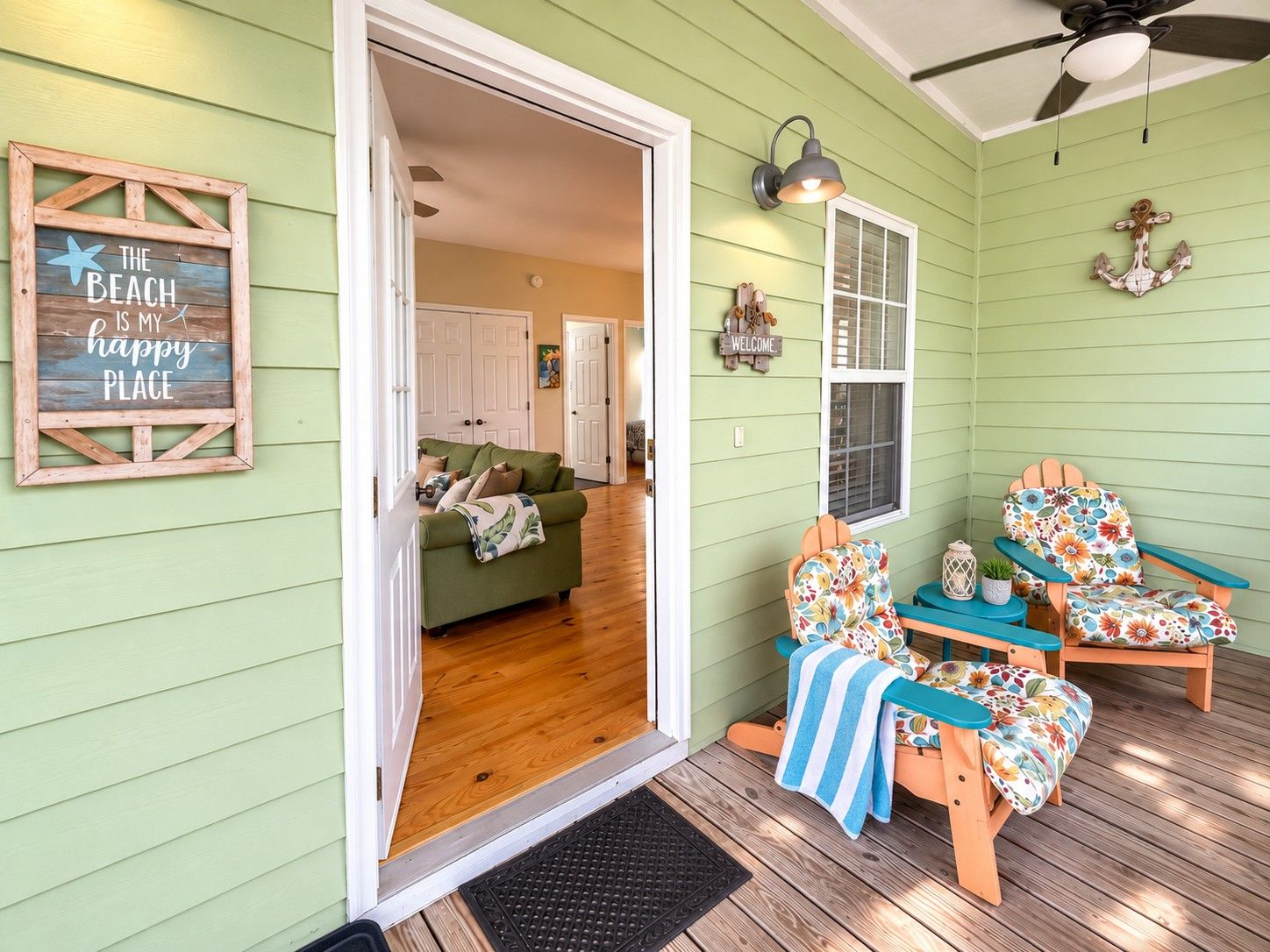 A cozy interior with a wooden door leading to a living room, a porch with two Adirondack chairs, and a wall-mounted light fixture.