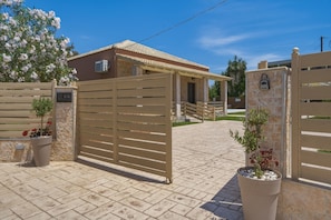 A gated entrance with a small building, a potted plant, and a sign with 'VA' on it.