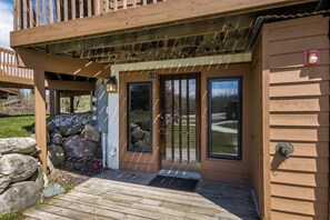 Una casetta di legno con veranda, una porta con finestra e una cassetta delle lettere.