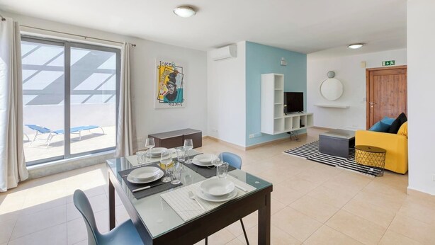A modern living room with a dining area, a TV, and a yellow sofa. - The Joker s Penthouse at Roulette in St Julian s (St. Julian's)