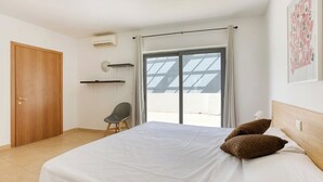 A bedroom with a large bed, a chair, a wardrobe, and a window with curtains. - The Joker s Penthouse at Roulette in St Julian s (St. Julian's)