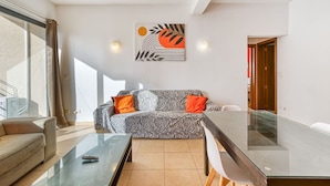 A modern living room with a zebra-patterned sofa, a glass coffee table, and a dining table with chairs. - Roulette Your St Julian s Base for a Fun Getaway (St. Julian's)