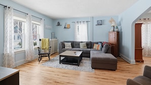 Un salon avec un canapé, une table basse et un plancher en bois.