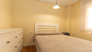 Une chambre à coucher avec un lit, une commode et une table de chevet.