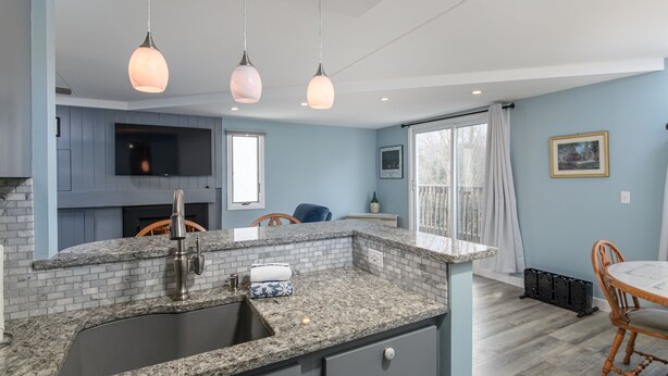 A kitchen with granite countertops, a sink, and pendant lighting. - Bridges 76 2 Bedroom Condo (Warren)