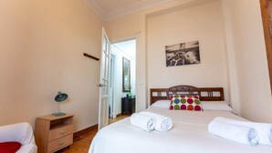 A bedroom with a bed, a nightstand, a desk, and a chair. - Your Bright Retreat in the Heart of Santander (Santander)