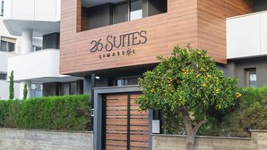 Een modern gebouw met een bord waarop staat '26 SUITES LIMASSO'.