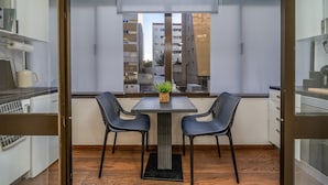A balcony with a table and chairs, a potted plant, and a view of buildings. - Studio 'Zizas House' with Wi-Fi and Air Conditioning (Portimão)