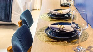 A dining table set with black plates, gold napkins, and a wine glass. - StayHome Beira-Mar Copacabana Posto 6 (Rio de Janeiro)