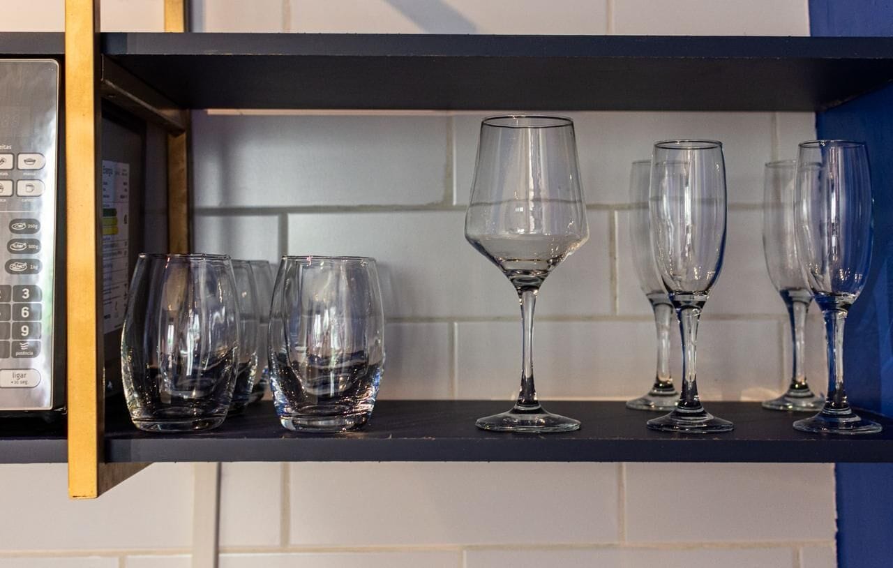 Un comptoir de cuisine avec une machine à café et plusieurs verres à vin.