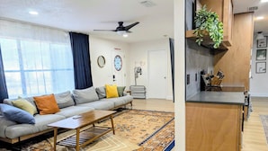 Uma sala de estar moderna com sofá, mesa de centro e tapete estampado.