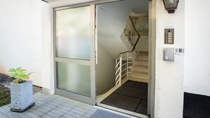 A sliding glass door leading to a staircase with a metal railing. - Gästehaus Elena (Kassel)