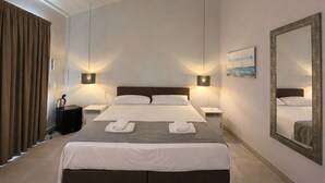 Ein großes Bett mit zwei Nachttischen, einem Spiegel und einem Gemälde an der Wand.