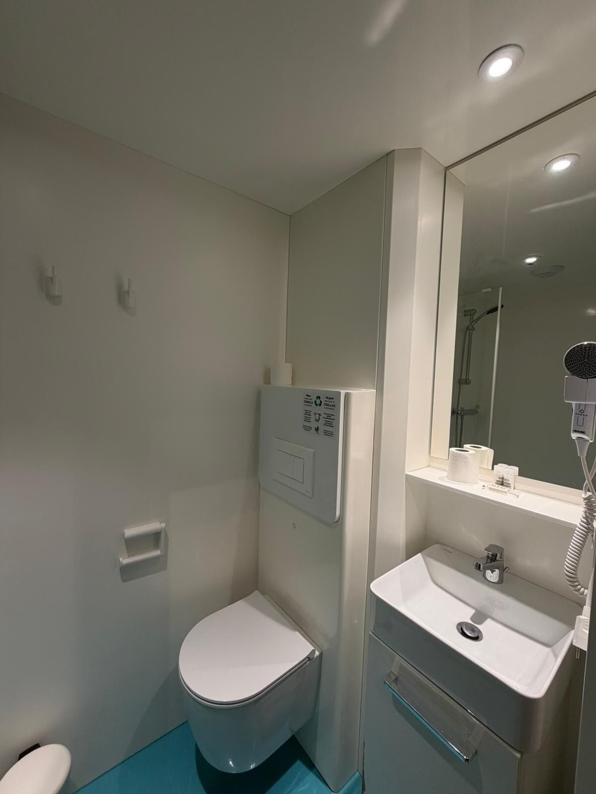 A modern bathroom with a toilet, a sink, and a shower area.