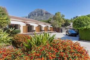 Una casa de dos pisos con una montaña al fondo.