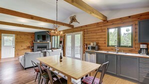 L’intérieur d’une cabane en rondins comprend un coin repas, une cuisine et une cheminée.