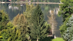 Un lac avec une ville en arrière-plan, entouré d’arbres et de verdure.