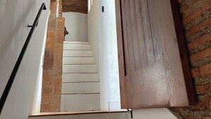 Eine Treppe mit einer Ziegelwand und einer Holztür.