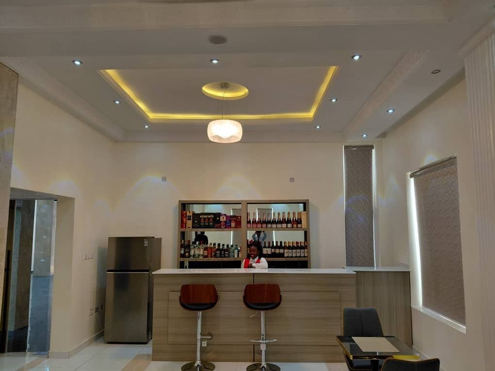 Una cucina moderna con un'area bar, un frigorifero e due sgabelli da bar.