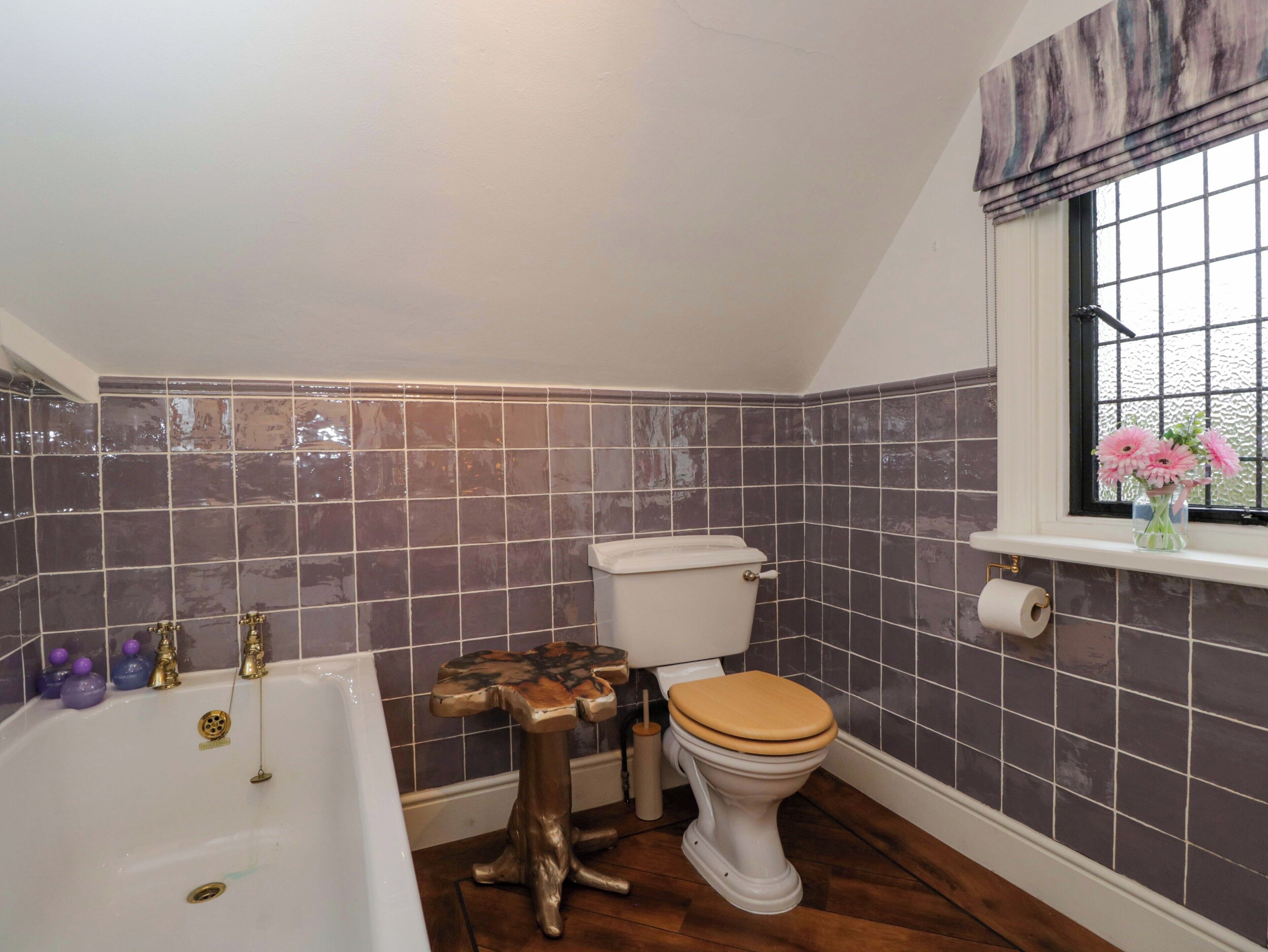 Une salle de bain avec une baignoire, des toilettes et une fenêtre donnant sur un beau paysage.