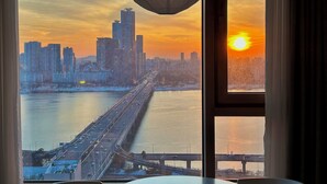 Eine Stadtlandschaft mit einer Brücke und Gebäuden bei Sonnenuntergang.