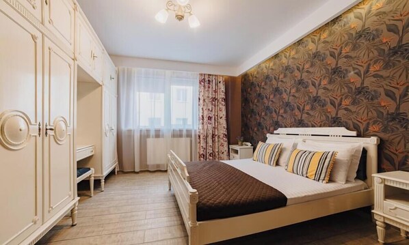 Un dormitorio con cama, armario y papel tapiz floral.