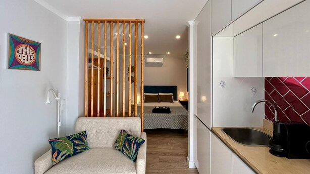 A compact living space with a kitchenette, a bed, and a seating area. - Villa Medusa Beach Studios, Seahorse (Parede)
