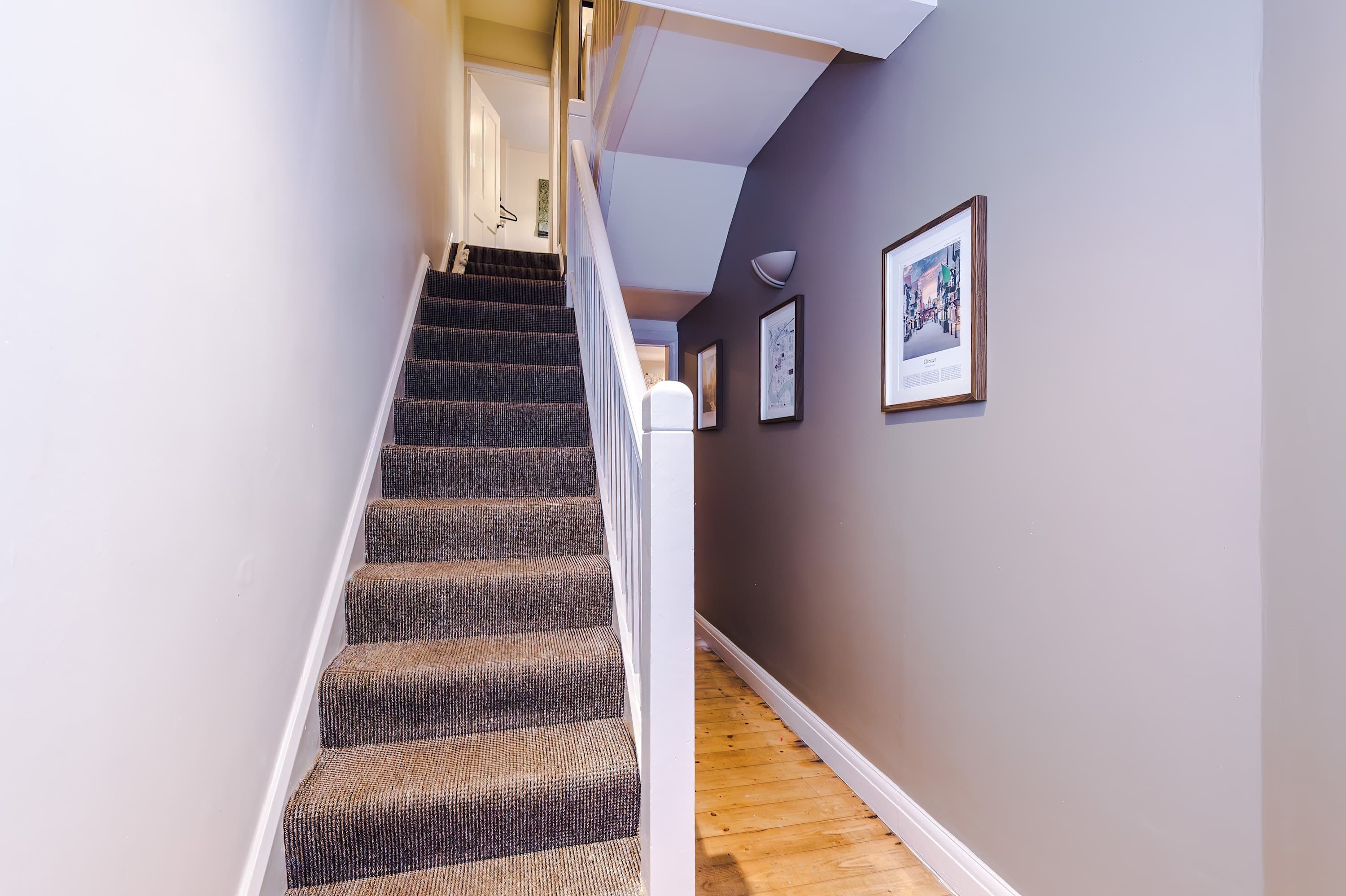 A staircase with carpeted steps leading to a landing.