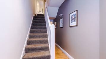 A staircase with carpeted steps leading to a landing.