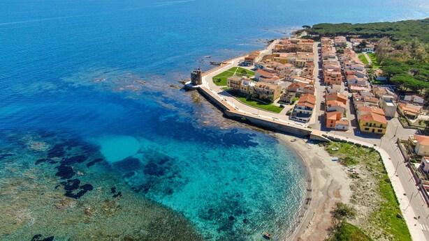 An aerial view of a coastal town with a fortified structure, clear blue waters, and a mix of residential buildings. - Sardinian Flat Close to Stunning Beaches (Siniscola)