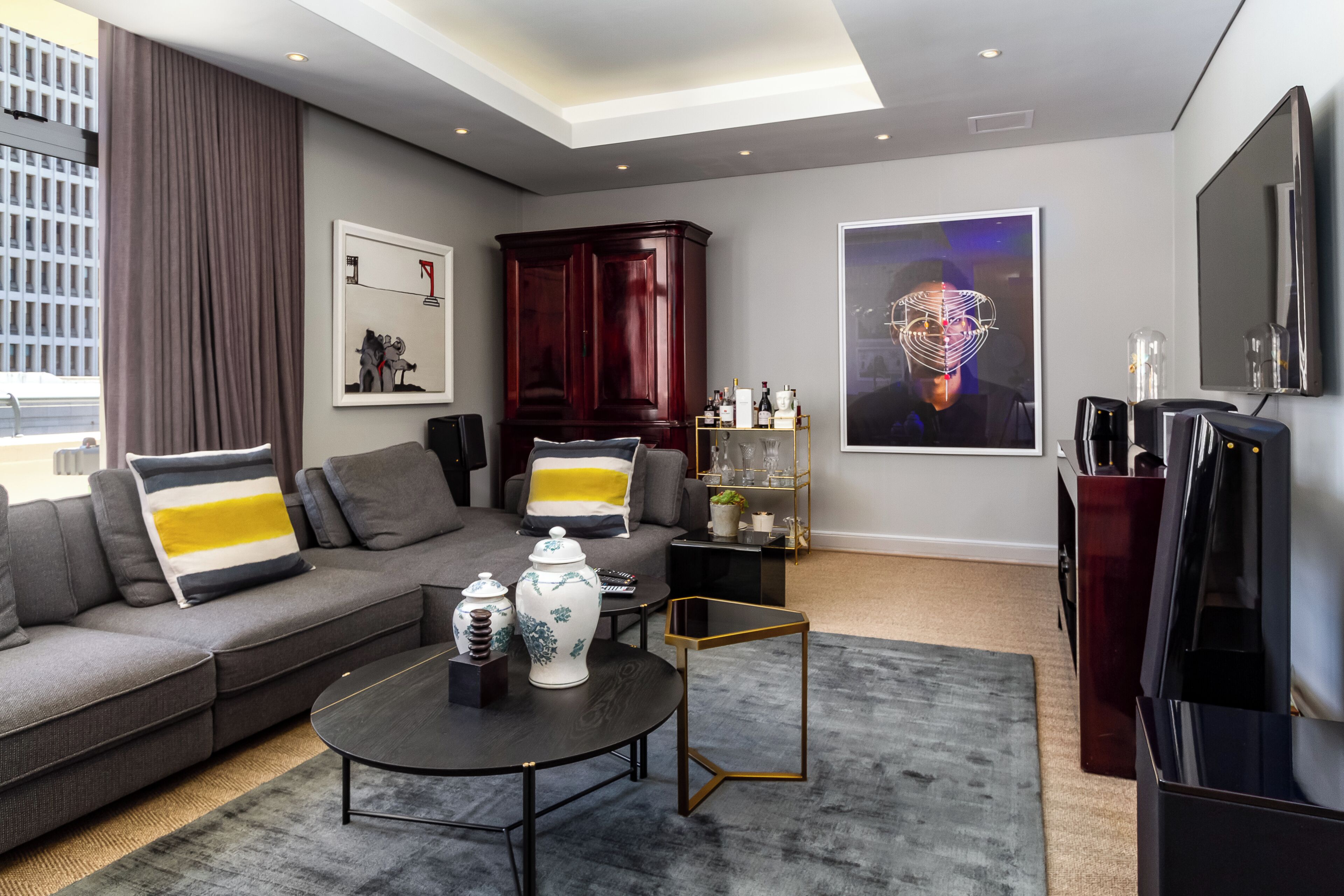 A modern living room with a sofa, coffee table, and artwork on the walls.